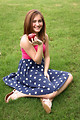 Free Stock Photo: A beautiful young girl holding an apple in the grass