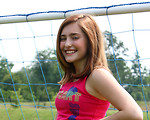 Free Stock Photo: A cute young girl posing by a soccer goal.