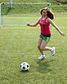 Free Stock Photo: A cute young girl kicking a soccer ball