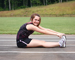 Free Stock Photo: A cute young girl doing stretches on a track field
