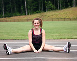 Free Stock Photo: A cute young girl doing stretches on a track field