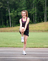 Free Stock Photo: A cute young girl doing stretches on a track field
