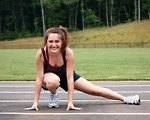 Free Stock Photo: A cute young girl doing stretches on a track field