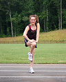Free Stock Photo: A cute young girl doing stretches on a track field