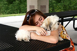 Free Stock Photo: A cute young girl resting with a small dog