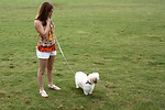 Free Stock Photo: A cute young girl walking her dog on the grass