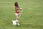 Free Stock Photo: A cute young girl walking her dog on the grass