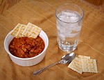 Free Stock Photo: A bowl of beef chili and crackers with a glass of water