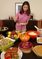 Free Stock Photo: A young Asian woman serving herself food from a dining table
