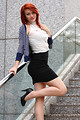 Free Stock Photo: A beautiful young woman dressed in business attire posing near a building.