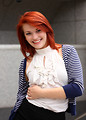 Free Stock Photo: A beautiful young woman dressed in business attire posing near a building.