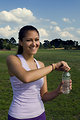 Free Stock Photo: A young woman drinking bottled water outdoors before exercising