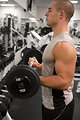 Free Stock Photo: A healthy young man lifting weights in a gym