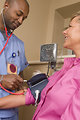Free Stock Photo: A male nurse taking the blood pressure of a woman
