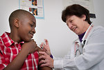 Free Stock Photo: A young African-American boy receiving a vaccination shot from his doctor
