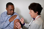 Free Stock Photo: An African-American man receiving a vaccination shot from his doctor