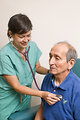 Free Stock Photo: A female doctor examining an elderly male patient