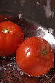 Free Stock Photo: Two fresh tomatoes being washed under running water