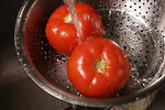Free Stock Photo: Two fresh tomatoes being washed under running water