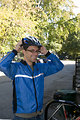 Free Stock Photo: This photograph depicts a smiling male bicyclist, who was about to embark on a bicycle ride, but before which was in the process of donning his safety helmet.