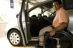 Free Stock Photo: A disabled man in a wheelchair getting out of a car