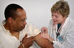 Free Stock Photo: A nurse giving a middle-aged man a vaccination shot