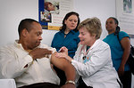 Free Stock Photo: A nurse giving a middle-aged man a vaccination shot