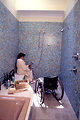 Free Stock Photo: A woman in a wheelchair getting into a shower