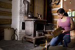 Free Stock Photo: A woman placing wood into a stove