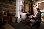 Free Stock Photo: A woman placing wood into a stove