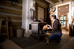 Free Stock Photo: A woman placing wood into a stove