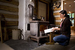 Free Stock Photo: A woman placing wood into a stove