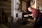 Free Stock Photo: A man placing wood into a stove
