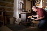 Free Stock Photo: A man placing wood into a stove
