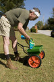Free Stock Photo: A man fertilizing his lawn with a spreader