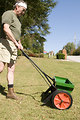 Free Stock Photo: A man fertilizing his lawn with a spreader