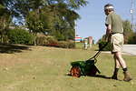 Free Stock Photo: A man fertilizing his lawn with a spreader