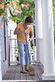 Free Stock Photo: A woman sweeping her front porch
