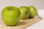 Free Stock Photo: Green Granny Smith apples on a wooden cutting board.