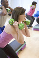 Free Stock Photo: This image depicts a class in session, the purpose of which was to instruct a number of Centers for Disease Control (CDC) employees through an aerobic step session, consisting of attendees following the participatory commands of an instructor. In this particular scene, while standing, attendees held small, 2.5lb dumbbells in both their hands on either side of their head, building upper body strength while aerobicizing.