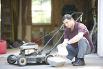 Free Stock Photo: A man working on his lawnmower