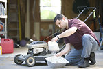 Free Stock Photo: A man working on his lawnmower