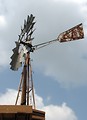 Free Stock Photo: An old farm windmill in a blue cloudy sky