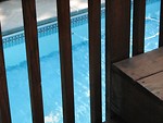 Free Stock Photo: Swimming pool through a wooden fence