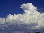 Free Stock Photo: Thick white clouds in a blue sky above mountains