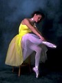 Free Stock Photo: A ballerina sitting on a stool tying her slipper