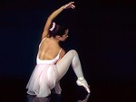 Free Stock Photo: A ballerina posing on the floor with a dark background