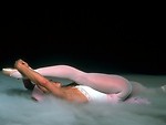Free Stock Photo: A ballerina stretching on the floor with smoke