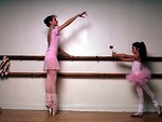 Free Stock Photo: Two ballerinas in pink practicing on a barre with a rose
