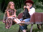 Free Stock Photo: Young boy and girl sitting in wheelbarrow with camera